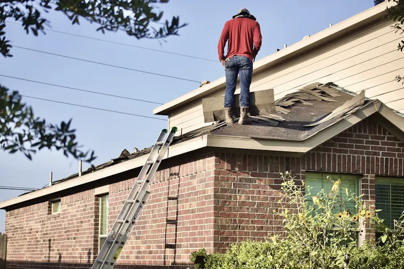 Professional roofer working on a residential roof in Ridgewood
